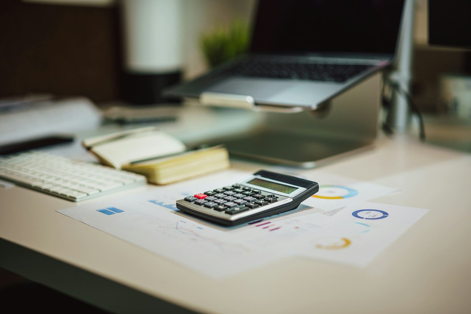 Documentos de contabilidade e uma calculadora sobre uma mesa de escritório.